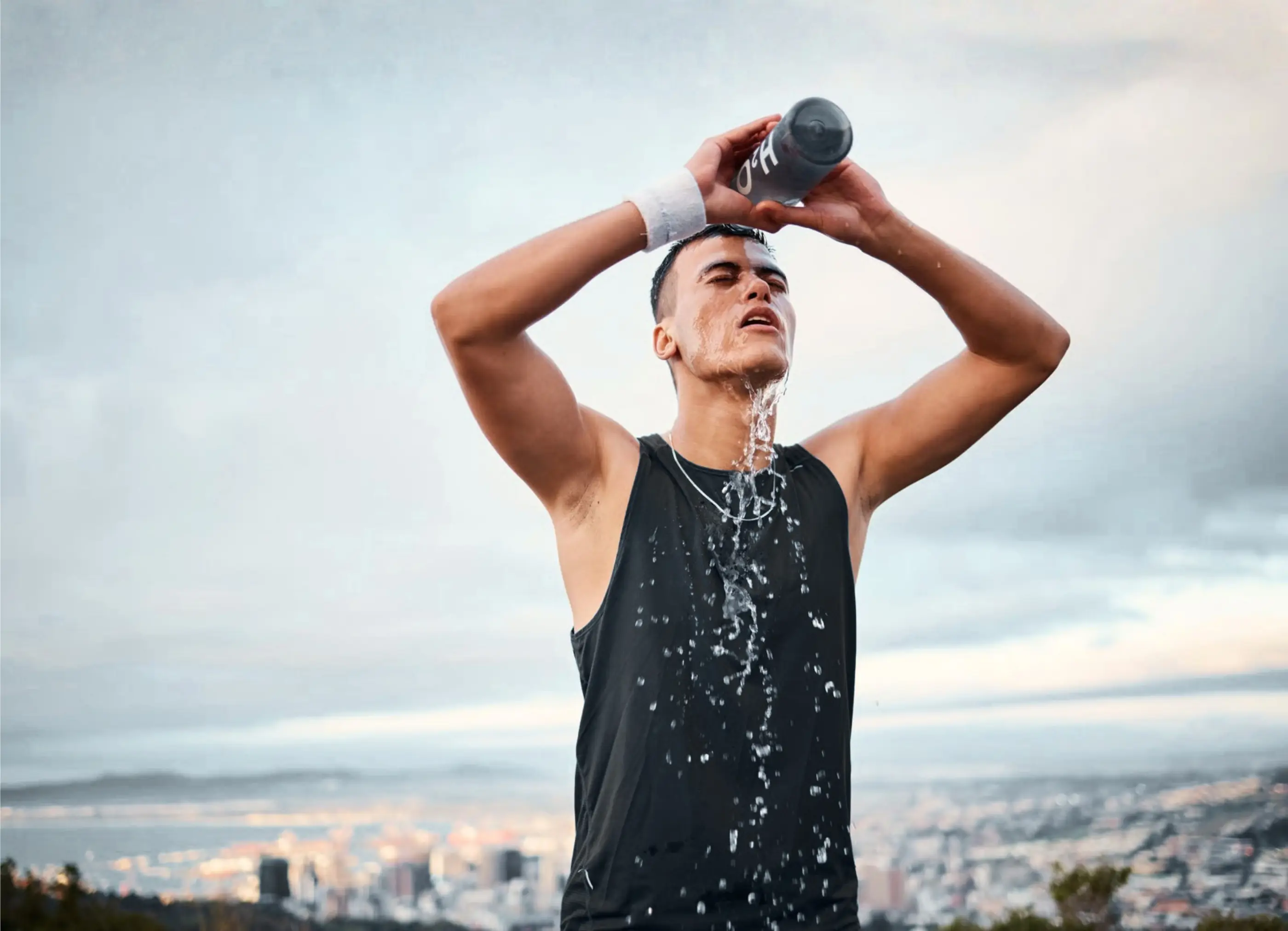 An athlete pouring water over their head after training